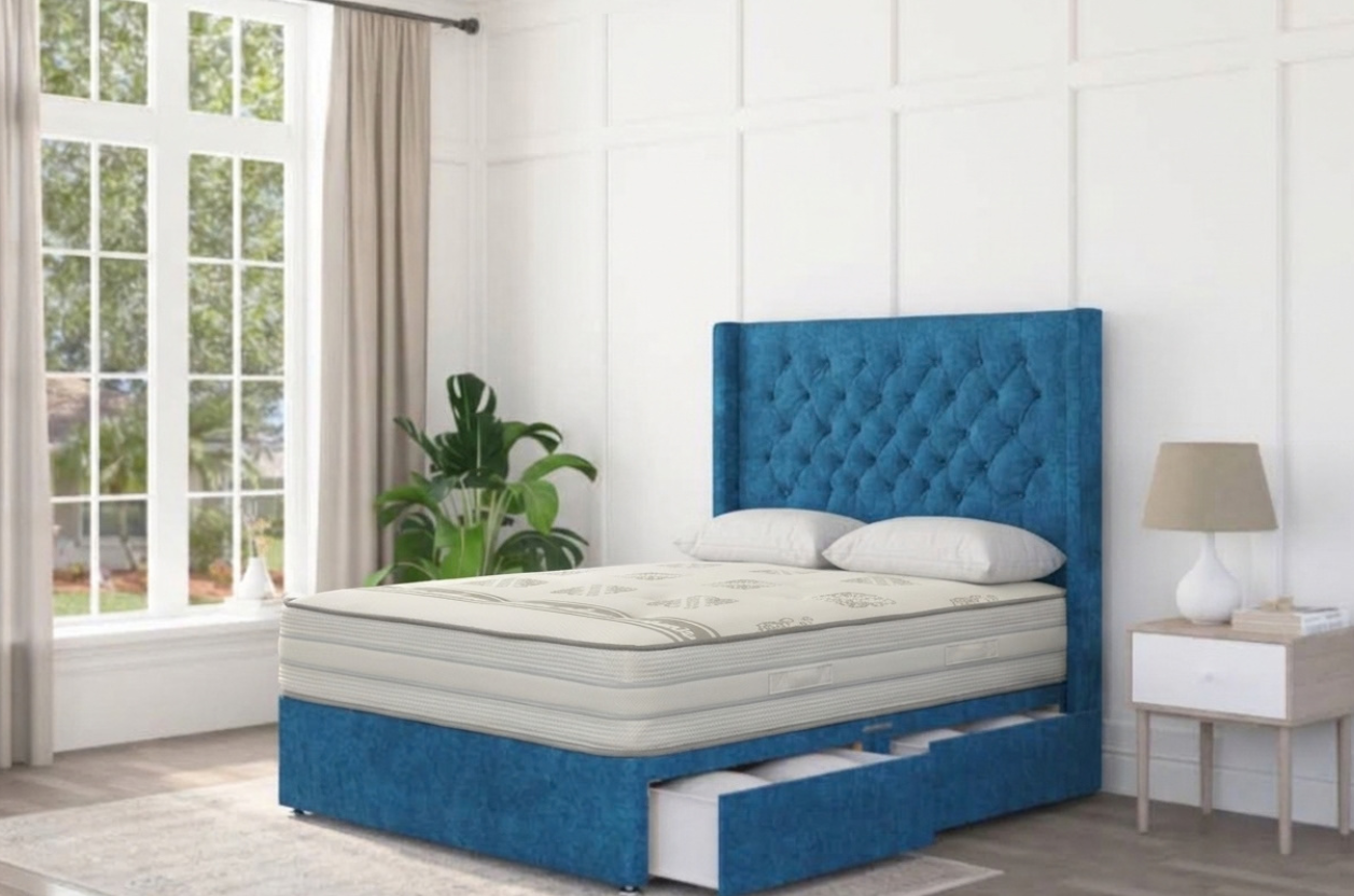A pocket sprung mattress displayed on a blue divan bed with a chesterfield headboard, located in a modern interior.